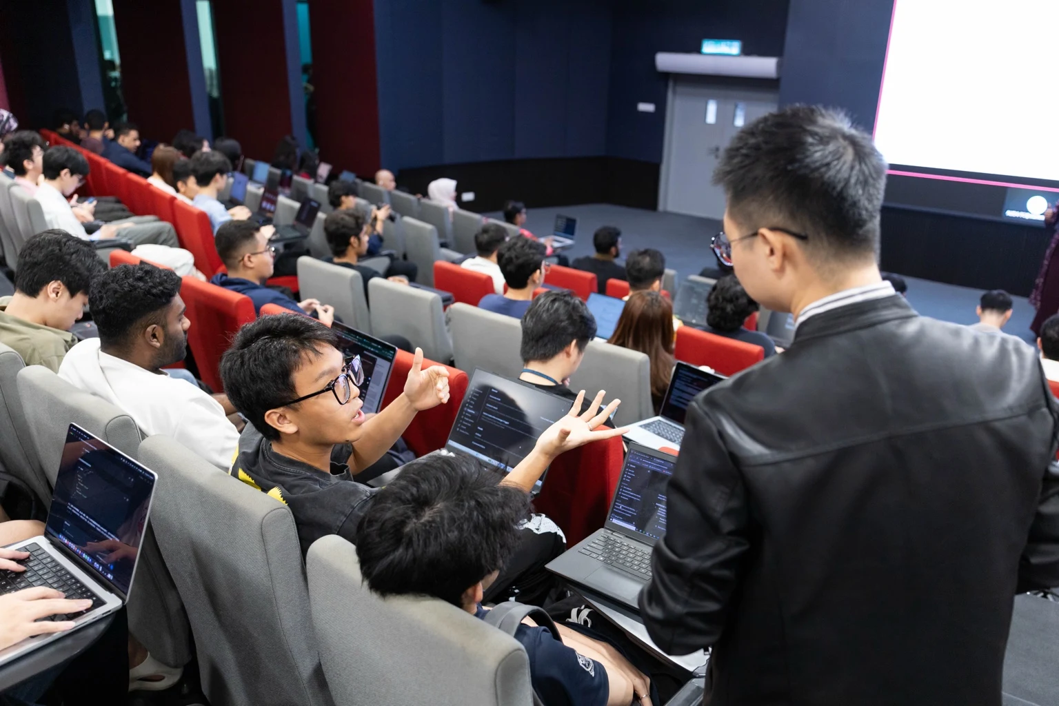William Soon guiding students during AI training in an Asia Pacific University auditorium